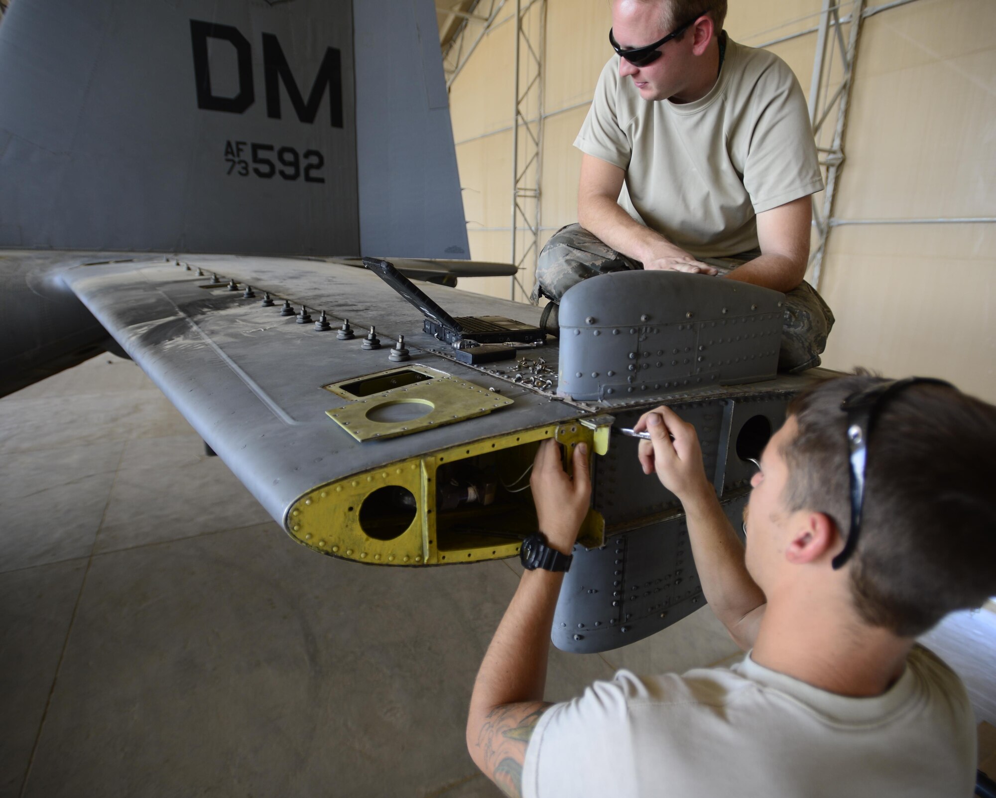 U.S. Air Force Senior Airman Christopher Lamb, 386th Expeditionary Aircraft Maintenance Squadron aerospace maintenance operator, tightens a bolt while Staff Sgt. Sean Jones, 386th EAMXS aerospace maintenance craftsman, reviews the training operating manual at an undisclosed location in Southwest Asia, Sept. 25, 2015. Maintainers perform regular inspections and preventative measures on aircraft to enhance Operation Inherent Resolve mission capabilities. (U.S. Air Force photo by Senior Airman Racheal E. Watson/Released)