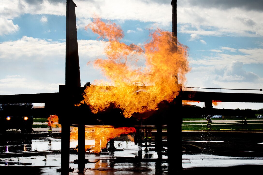 A mock F-15 aircraft burns as first responders and firefighters arrive on scene to conduct firefighting training on Royal Air Force Lakenheath, England, Sept. 17, 2015. The airmen are firefighters assigned to the 48th Civil Engineer Squadron Fire Department, and are required to conduct training twice a year to maintain their skills and keep their qualifications current. U.S. Air Force photo by Senior Airman Trevor T. McBride