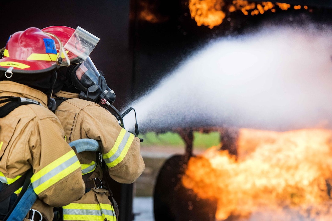 U.S. Air Force Col. Robert Novotny, right, commander of the 48th Fighter Wing, listens to a firefighter during firefighting training at the burn pit on Royal Air Force Lakenheath, England, Sept. 17, 2015. 
Novotny joined the 48th CES Fire Department training to better understand the required skills and techniques to effectively put out an aircraft fire. U.S. Air Force photo/Senior Airman Trevor T. McBride