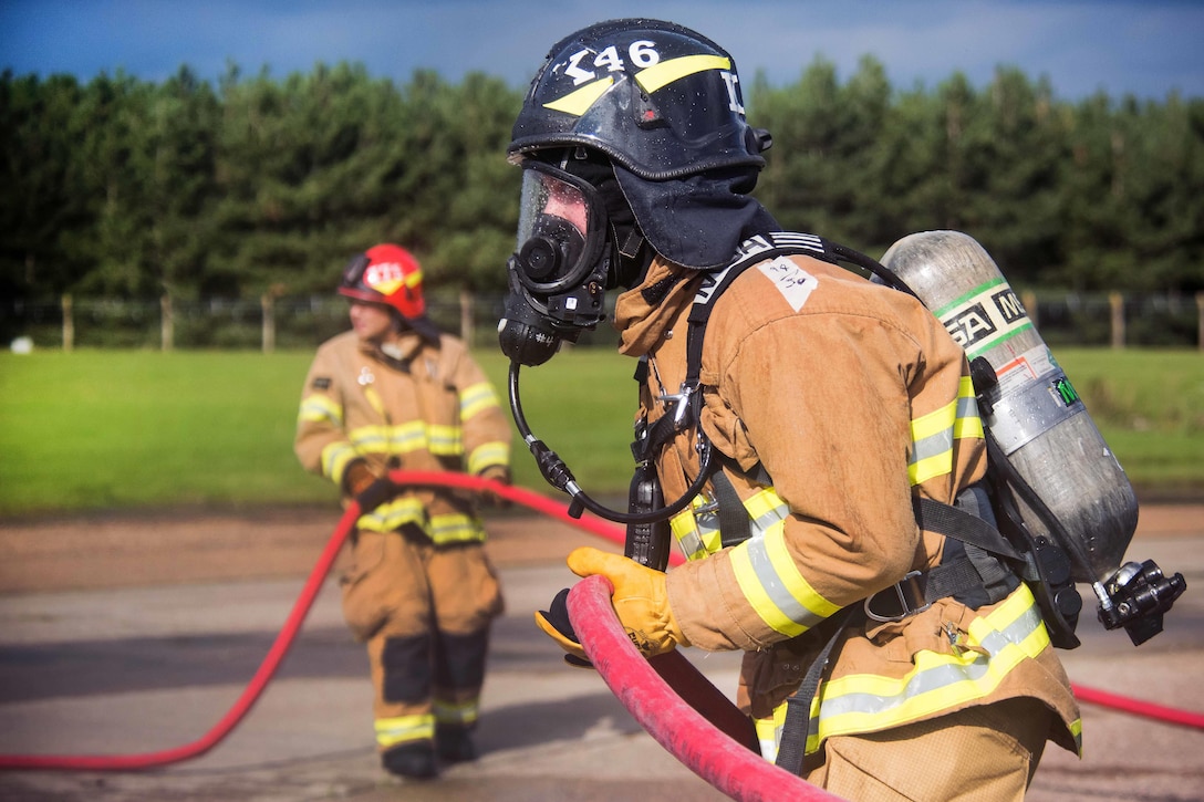 U.S. Air Force 2nd Lt. Andrew Fenner holds a fire hose during firefighting training at the burn pit on Royal Air Force Lakenheath, England, Sept. 17, 2015. Fenner is a project programmer assigned to the 48th Fighter Wing Civil Engineer Squadron. U.S. Air Force photo by Senior Airman Trevor T. McBride

