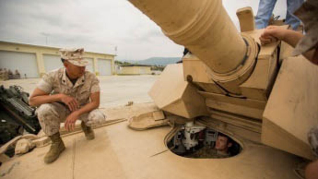 A U.S. Marines with Combined Arms Company show an Army soldier an M1A1 Abrams tank after attending the CAC opening ceremony at Novo Selo Training Area, Bulgaria, Sept. 23, 2015. The ceremony marks the first rotation of CAC that will advance training  exercises with NATO allies by bringing improved mechanized and indirect-fire capabilities. 