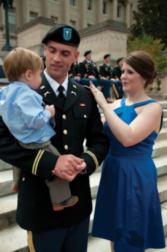 Kentucky Army National Guard 2nd Lt. Kevin Morris, military policeman with the 617th MP Company out of Richmond, Ky., has his shoulder boards pinned on by his wife, Cynthia, during the graduation of his Officer Candidate School class in Frankfort, Ky., Sept. 27, 2015. U.S. Army photo by Staff Sgt. David Bolton
