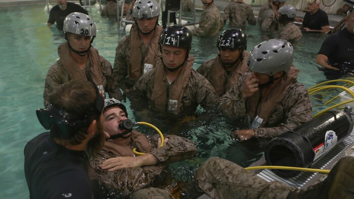 A Marine with Echo Company, Battalion Landing Team, 2nd Battalion, 6th Marine Regiment, prepares to submerge underwater while wearing a supplemental emergency breathing device at Marine Corps Base Camp Lejeune, North Carolina, Sept. 22, 2015. The company participated in the submerged vehicle egress training to gain confidence in their abilities to safely exit a sinking amphibious assault vehicle in preparation for their upcoming deployment with the 26th Marine Expeditionary Unit.