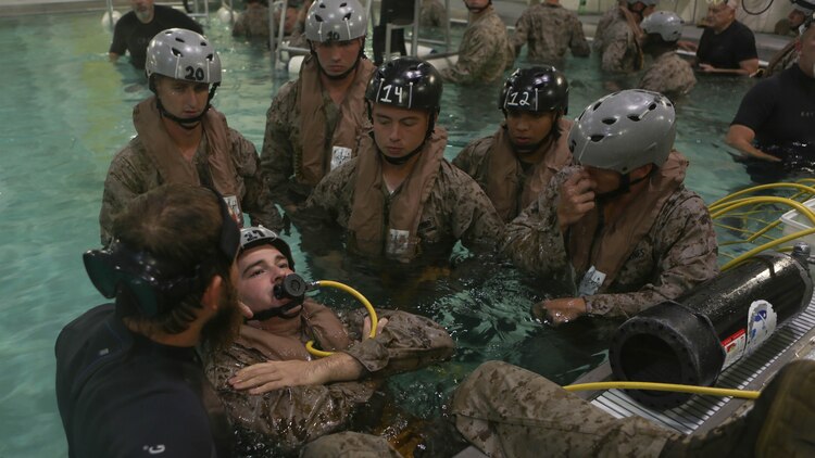 A Marine with Echo Company, Battalion Landing Team, 2nd Battalion, 6th Marine Regiment, prepares to submerge underwater while wearing a supplemental emergency breathing device at Marine Corps Base Camp Lejeune, North Carolina, Sept. 22, 2015. The company participated in the submerged vehicle egress training to gain confidence in their abilities to safely exit a sinking amphibious assault vehicle in preparation for their upcoming deployment with the 26th Marine Expeditionary Unit.