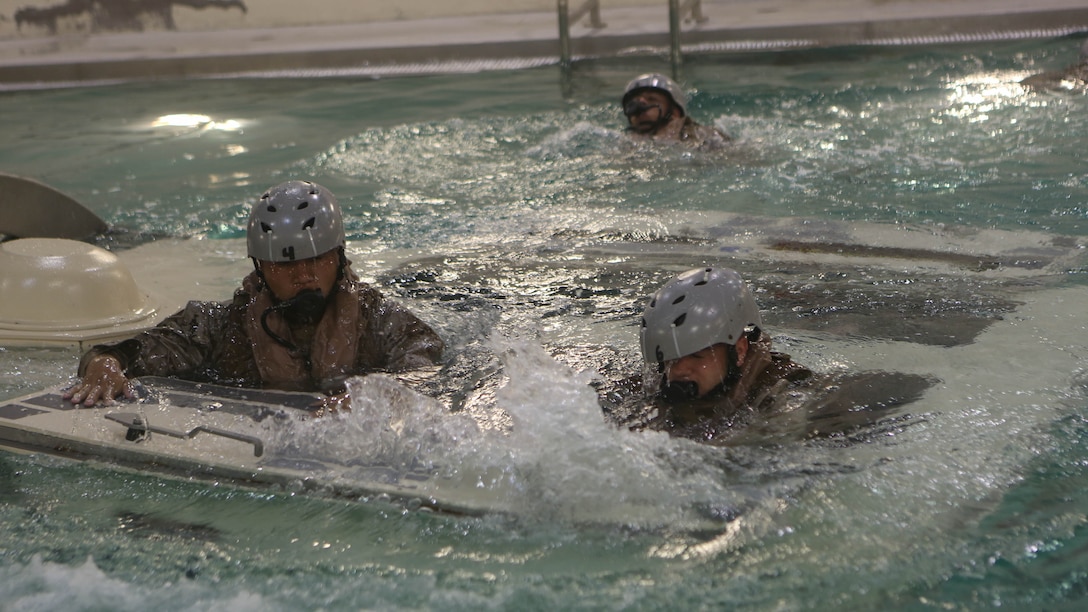 Marines with Echo Company, Battalion Landing Team, 2nd Battalion, 6th Marine Regiment, emerge from a simulated amphibious assault vehicle at Marine Corps Base Camp Lejeune, North Carolina, Sept. 22, 2015. The company participated in the submerged vehicle egress training to gain confidence in their abilities to safely exit a sinking amphibious assault vehicle in preparation for their upcoming deployment with the 26th Marine Expeditionary Unit. 