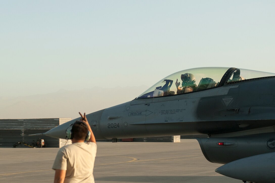 A U.S. airman marshals an F-16 Fighting Falcon aircraft on Bagram Airfield, Afghanistan, before it flies a combat sortie  Sept. 15, 2015. U.S. Air Force photo by Tech. Sgt. Joseph Swafford