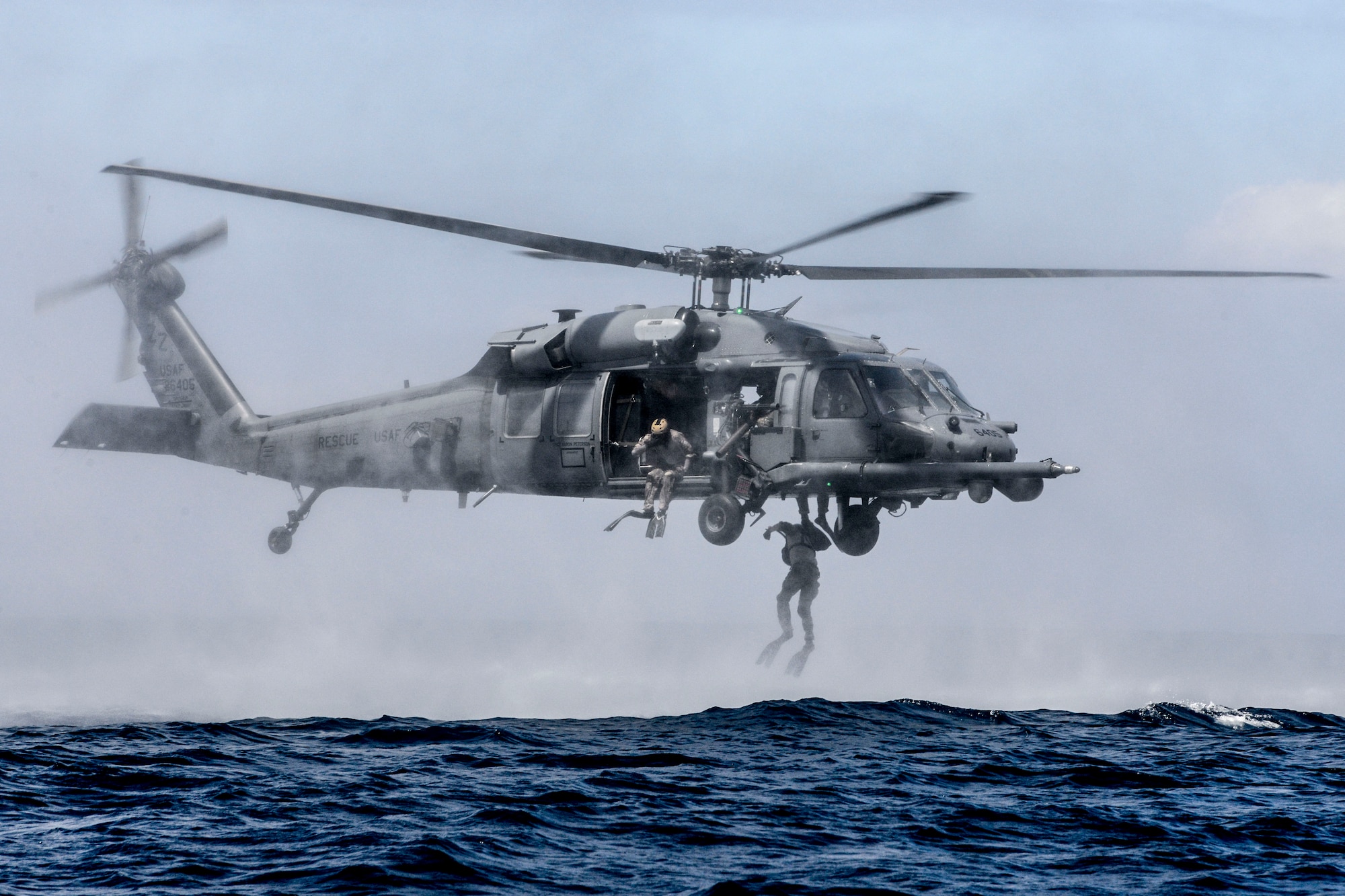 Airmen from the 320th Special Tactics Squadron at Kadena Air Base, Japan, perform a helo-casting jump out of an HH-60G Pave Hawk from the 33rd Rescue Squadron during an amphibious operations exercise Sept. 22, 2015, off the west coast of Okinawa, Japan. Team members are qualified in nonstandard methods of infiltration,  including static line, military free fall, and closed and open circuit diving. (U.S. Air Force photo/Senior Airman John Linzmeier)