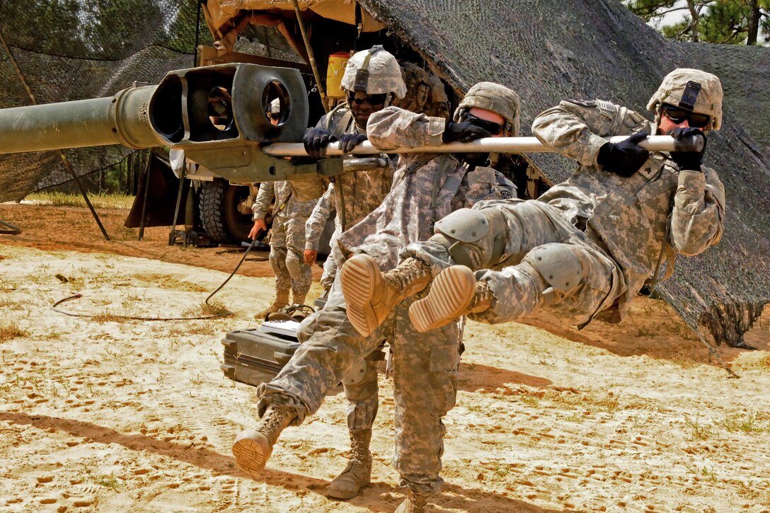 Members of an M777A2 howitzer crew use their body weight to move the 10,000-pound cannon tube during the Division Artillery Readiness Test on Fort Bragg, N.C., Sept. 18, 2015. U.S. Army photo by Capt. Joe Bush