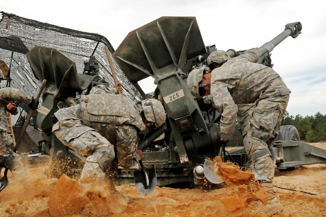 Soldiers furiously dig in the M777A2  to stabilize their howitzer for firing missions during the Division Artillery Readiness Test on Fort Bragg, N.C., Sept. 18, 2015. U.S. Army photo by Capt. Joe Bush