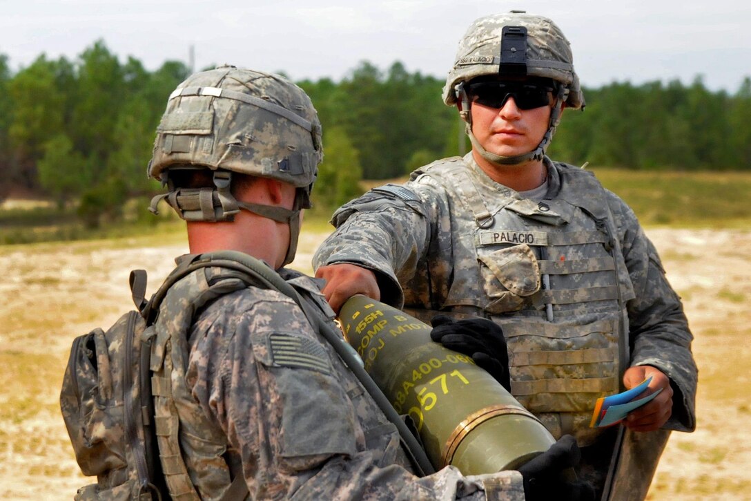 Army Staff Sgt. Pablo Palacio, right, checks the 155mm round and fuse for any deficiencies before the gunner loads it in the tube during the Division Artillery Readiness Test on Fort Bragg, N.C., Sept. 18, 2015. Palacio is a crew chief assigned to the 82nd Airborne Division, 2nd Battalion, 319th Airborne Field Artillery Regiment. U.S. Army photo by Capt. Joe Bush