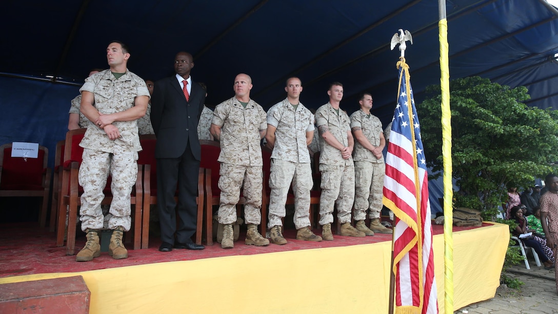Marines watch the National Surveillance Police graduation proceedings, Sept. 25, 2015, at the Benin National Police Academy in Cotonou, Benin. More than 150 NPS students graduated from a monthlong U.S. Marine Corps training evolution that included weapons handling, combat marksmanship, patrolling, close-quarters combat, tactical site exploitation, tactical questioning and the operations order process.
