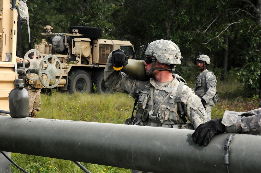 A soldier kisses his 155mm round for good luck as he continues to load the 100-pound rounds into the back of his vehicle during the Division Artillery Readiness Test on Fort Bragg, N.C., Sept. 18, 2015. U.S. Army photo by Capt. Joe Bush