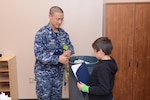 Navy Lt. Cmdr. Brett Sandman, assistant site director of DLA Distribution Norfolk, Va., at New London, Conn., presents a certificate to a Northeast Academy student during the recent Groton ROCKS program.