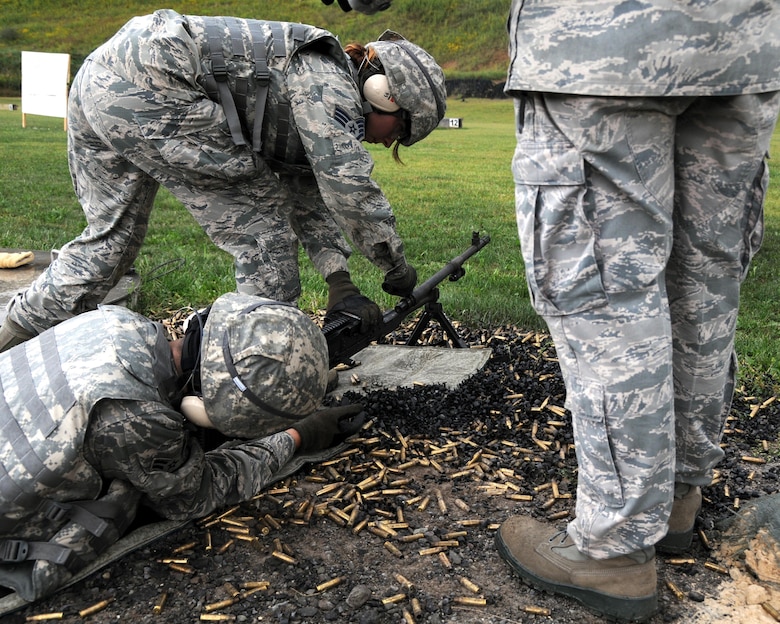 Staff Sgt. Katherine Modic, a member of the 910th Security Forces Squadron (SFS), changes the barrel on an M249 automatic rifle during training here, Sept. 10, 2015. Senior Airmen Neil Ahlstrom, also with the 910th SFS is firing the weapon at a practice range. The security forces airmen are participating in a four-day training mission to help refresh or familiarize themselves with different aspects of their jobs. (U.S. Air Force photo/ Tech. Sgt. Rick Lisum)