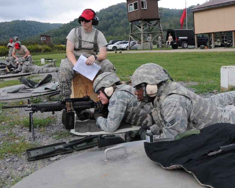 Senior Airman Brystal Thomas, a member of the 910th Security Forces Squadron (SFS), fires the M249 automatic rifle during training here, Sept. 10, 2015. Senior Airman Justin Herod, also a member of 910th SFS, serves Thomas as assistant gunner.  Senior Airman Danielle Massengil, another member of the 910th SFS, observes the airmen as their combat arms instructor. The security forces airmen are participating in a four-day training mission to help refresh or familiarize themselves with different aspects of their jobs. (U.S. Air Force photo/ Tech. Sgt. Rick Lisum)