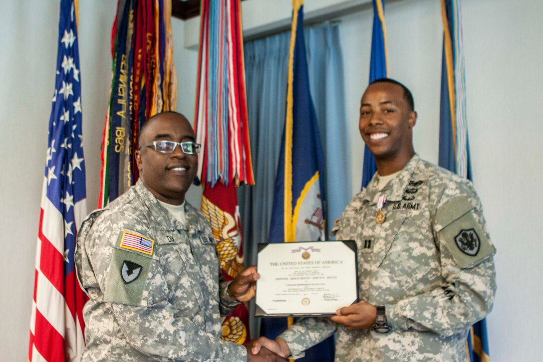 Army Brig. Gen. Richard Dix, DLA Distribution commander, left, presents the Defense Meritorious Service Medal to Army Capt. Domonick Sylve, aide-de-camp, on July 9. 