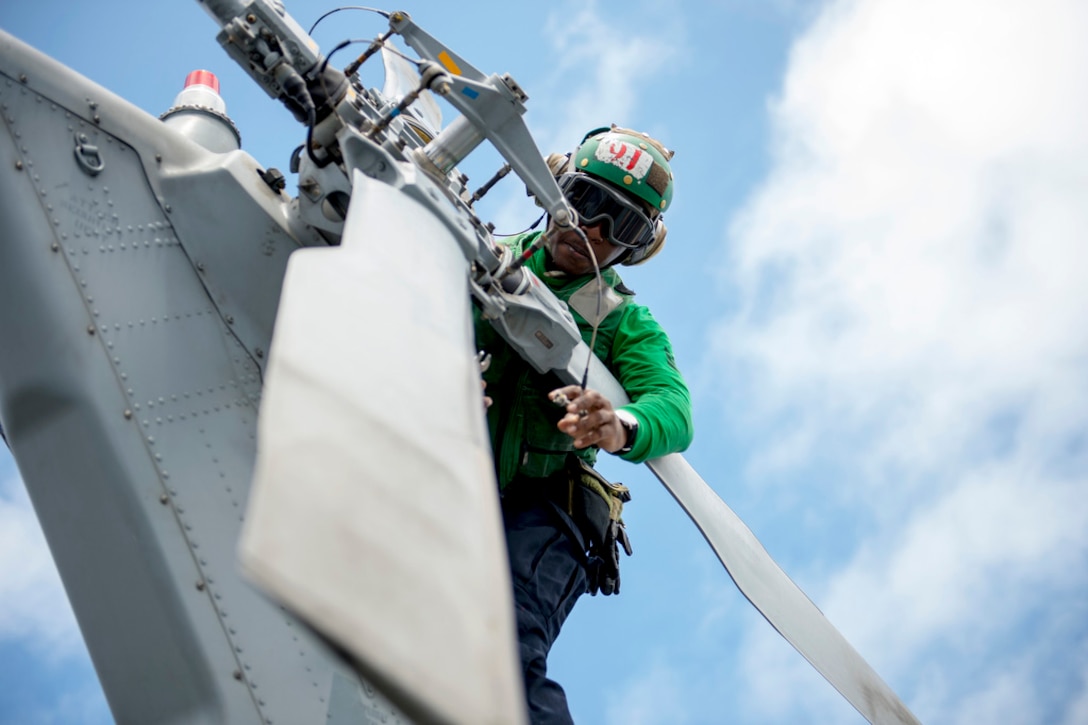 Navy Petty Officer 1st Class Jerome Duncan installs the tail rotor boot on an MH-60S Seahawk helicopter on the flight deck of the aircraft carrier USS George Washington in the Pacific Ocean, Sept. 25, 2015. The helicopter is assigned to Helicopter Sea Combat Squadron 4. The George Washington is preparing to deploy around South America for the Southern Seas 2015 deployment. U.S. Navy photo by Petty Officer 3rd Class Jessica Gomez
