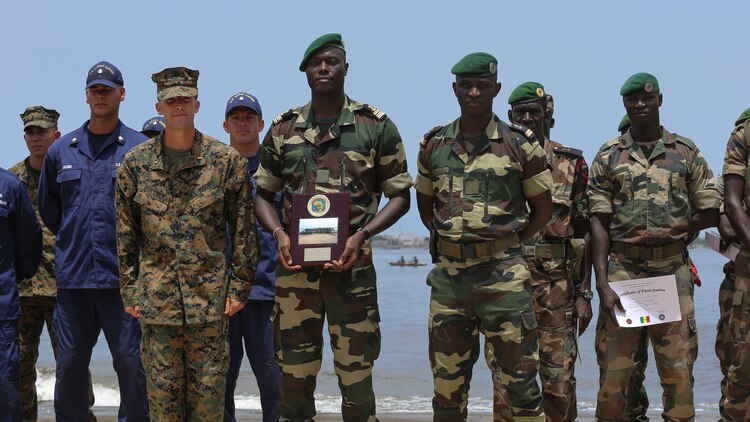 Second Lt. Aaron Burtner, security cooperation team leader, poses for a photo with Compagnie Fusilier de Marin Commandos after completing their final exercise with U.S. service members in Dakar, Senegal, September 17, 2015. The Marines and Coast Guardsmen with Special-Purpose Marine Air-Ground Task Force Crisis Response-Africa spent four weeks training the COFUMACO on basic infantry tactics and small-boat operations as a part of a Maritime Security Force Assistance mission to increase interoperability with Senegal’s and strengthen the bond between the partner nations. 