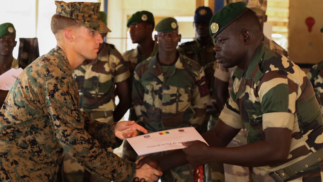 Second Lt. Aaron Burtner, security cooperation team leader, congratulates a Compagnie Fusilier de Marin Commando during his graduation ceremony after completing the final exercise with U.S. service members in Dakar, Senegal, September 17, 2015. The Marines and Coast Guardsmen with Special-Purpose Marine Air-Ground Task Force Crisis Response-Africa spent four weeks training the COFUMACO on basic infantry tactics and small-boat operations as a part of a Maritime Security Force Assistance mission to increase interoperability with Senegal’s and strengthen the bond between the partner nations. 