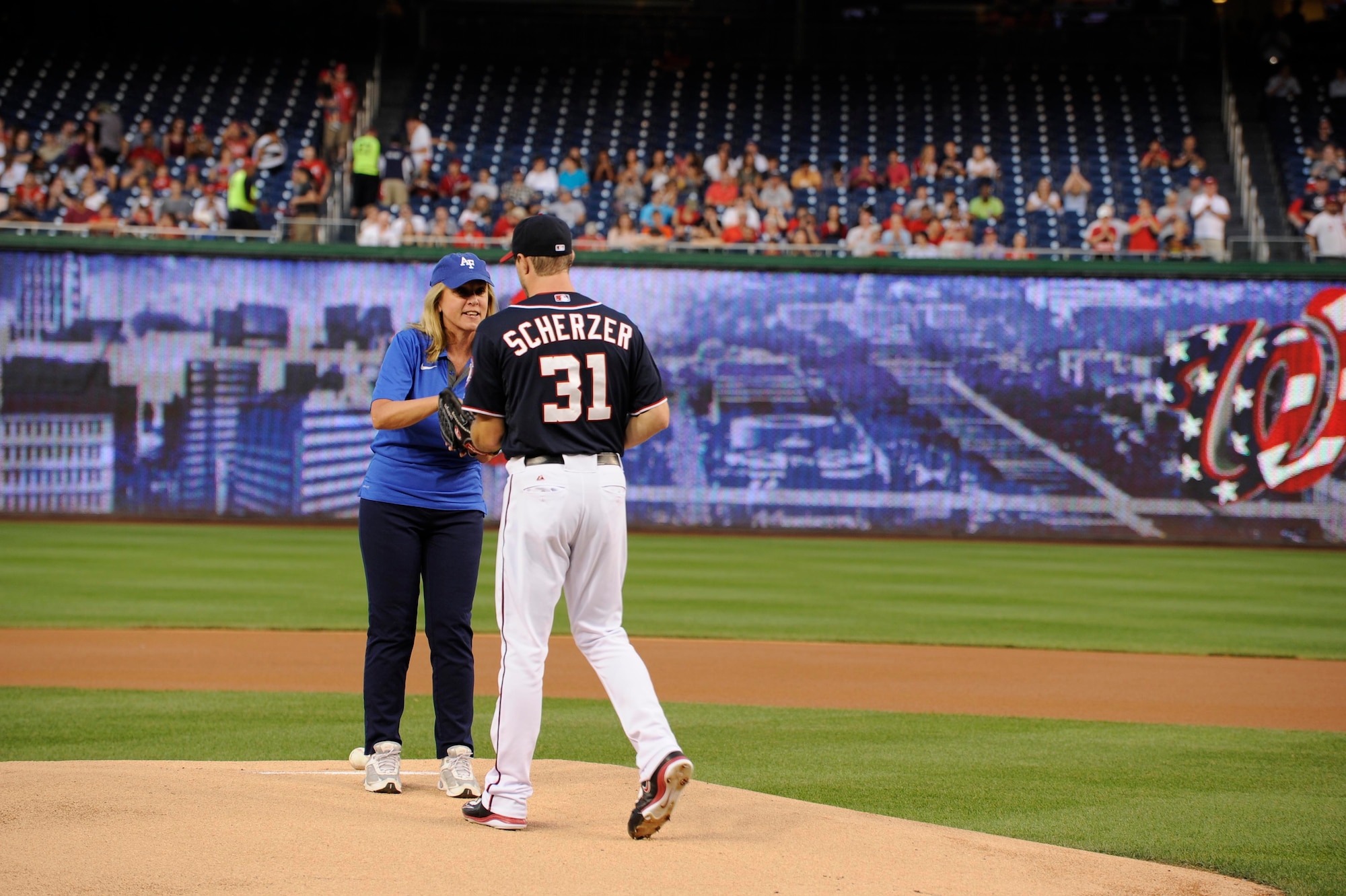 Secretary of the Air Force Deborah Lee James passes the game ball to Max Scherzer at Nationals Park in Washington, D.C., Sept. 18, 2015. Scherzer is a pitcher on the Washington Nationals baseball team. (Air Force photo/Staff Sgt. Whitney Stanfield)
