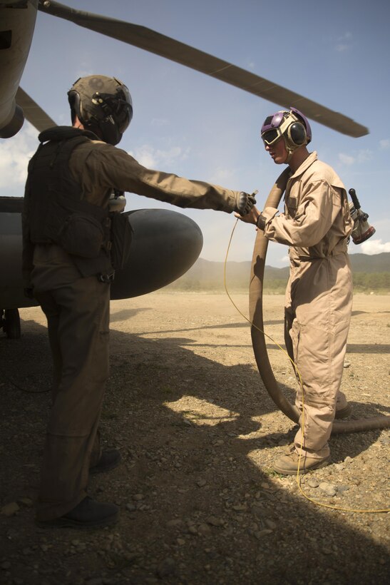 A U.S. Marine with Marine Heavy Helicopter Squadron 462, left, helps a Marine with Marine Wing Support Squadron 171 refuel a CH-53E Super Stallion rotary-wing aircraft at Aibano Training Area, Sept. 15, 2015. MWSS-171 provided fuel at a forward arming and refueling point during an assault transport. The assault transport supported a bilateral-air-assault comprehensive exercise during Forest Light 16-1. MWSS-171 is with Marine Aircraft Group 12, 1st Marine Aircraft Wing, III Marine Expeditionary Force. HMH-462 is with MAG 16, 3rd MAW, currently assigned to MAG 36, 1st MAW, III MEF. 