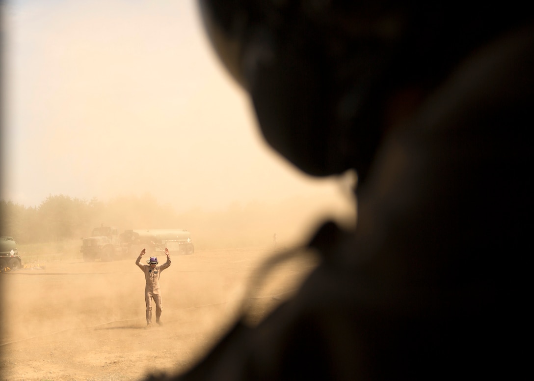 A U.S. Marine with Marine Wing Support Squadron 171 guides a CH-53E Super Stallion rotary-wing aircraft for takeoff at Aibano Training Area, Sept. 15, 2015. MWSS-171 provided fuel for HMH-462 at a forward arming and refueling point during an assault transport. The assault transport supported a bilateral air assault comprehensive exercise during Forest Light 16-1.  Forest Light is an exercise to increase interoperability of Japan Ground Self-Defense Force and U.S. Marine Corps forces. MWSS-171 is with Marine Aircraft Group 12, 1st Marine Aircraft Wing, III Marine Expeditionary Force. HMH-462 is with MAG 16, 3rd MAW, currently assigned to MAG 36, 1st MAW, III MEF. 