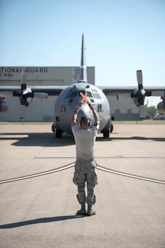 Air Force Senior Airman Paul Proctor II marshals a C-130 Hercules aircraft to its parking spot at the Kentucky Air National Guard Base in Louisville, Ky., Sept. 17, 2015, upon its return from a training sortie. A delegation of Djiboutian military members traveled aboard the plane during the sortie while visiting the base. Kentucky National Guard photo by Air Force Maj. Dale Greer