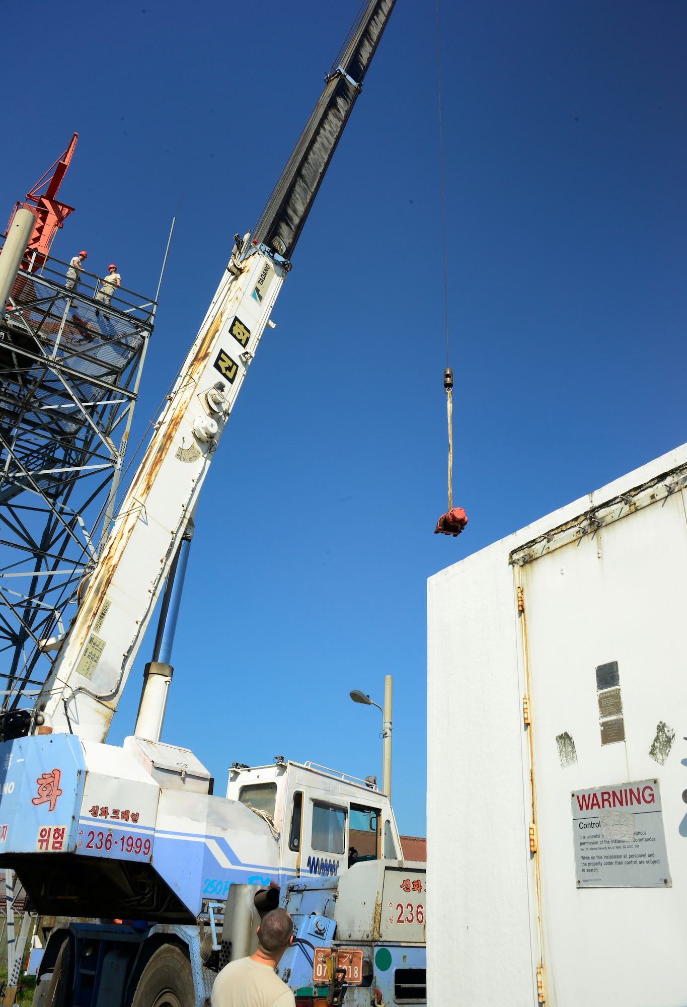 Airmen from the 51st Operations Support Squadron and the 51st Logistics Readiness Squadron watch as part of a GPN-20 airfield surveillance radar is lowered onto a truck bed on Osan Air Base, Republic of Korea, Sept. 15, 2015. The radar will be dismantled and shipped to Camp Lemonnier, Djibouti, to support the Combined Joint Task Force-Horn of Africa mission under U.S. Africa Command. By repurposing the older radar, the Department of Defense is saving $2 million. (U.S. Air Force photo/Senior Airman Kristin High)