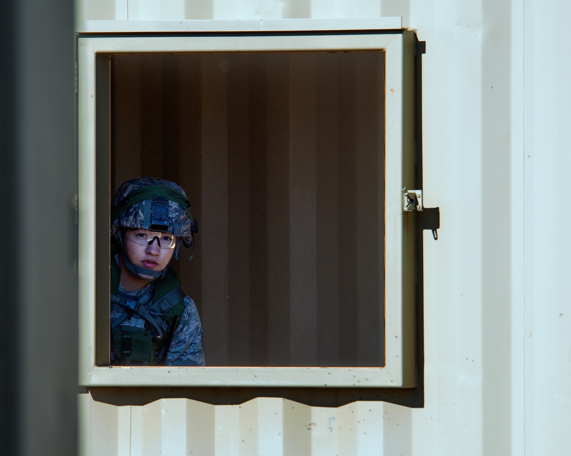 Staff Sgt. Amaris Serrano, 28th Bomb Wing, Ellsworth Air Force Base, S.D., looks out a window Sept. 24, 2015, during the tactical recapture portion of the 2015 Global Strike Challenge security forces competition on Camp Guernsey, Wyo. Airmen used windows as vantage points to survey locations before moving through an enemy occupied town. (U.S. Air Force photo by Senior Airman Brandon Valle)