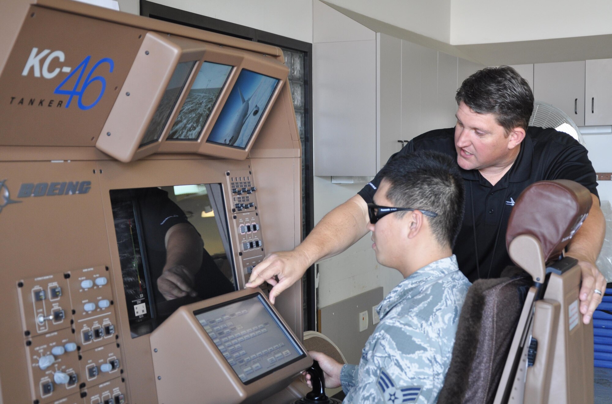 Senior Airman Yoonhong Min, 22nd Aerospace Medical Squadron bioenvironmental technician, tests the KC-46 Air Refueling Operator Station (AROS) under the instruction of Jeff Schommer, Boeing Logistics Supply representative Sept, 28, 2015, at McConnell Air Force Base, Kan. Boeing representatives visited McConnell for two days to give Airmen the opportunity to simulate an air refueling contact on KC-46A Pegausus. (U.S. Air Force photo by Tech. Sgt. Abigail Klein)
