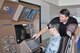 Senior Airman Yoonhong Min, 22nd Aerospace Medical Squadron bioenvironmental technician, tests the KC-46 Air Refueling Operator Station (AROS) under the instruction of Jeff Schommer, Boeing Logistics Supply representative Sept, 28, 2015, at McConnell Air Force Base, Kan. Boeing representatives visited McConnell for two days to give Airmen the opportunity to simulate an air refueling contact on KC-46A Pegausus. (U.S. Air Force photo by Tech. Sgt. Abigail Klein)