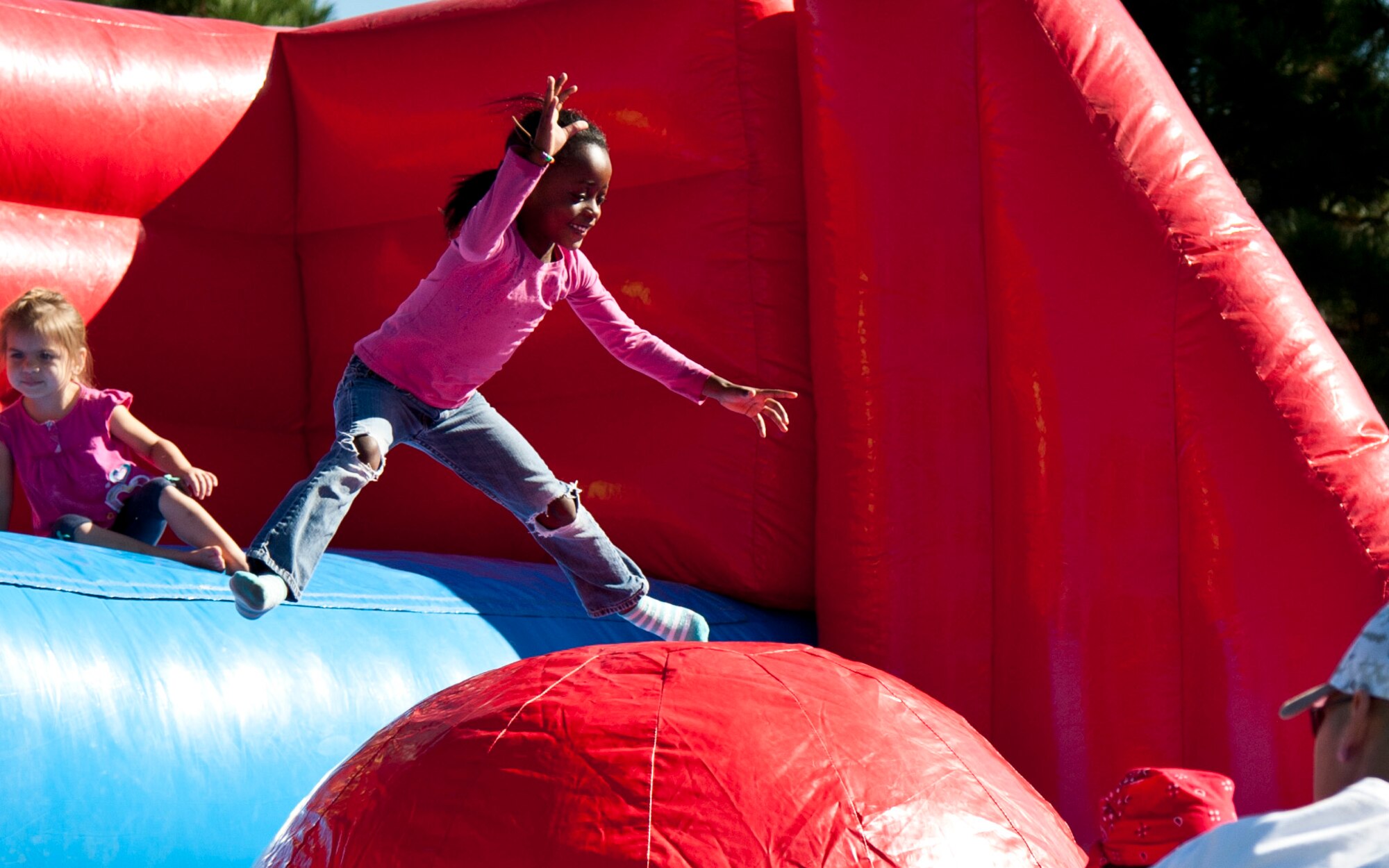 PETERSON AIR FORCE BASE, Colo. – Jayla Ray, 6 years old, pounces on an inflatable obstacle course during Nickelodeon’s Worldwide Day of Play at Patriot Park, Sept 26, 2015. The event encouraged children to maintain healthy lifestyles through various activities including a climb wall, inflatable obstacle course, bounce houses, games, healthy snacks, a Color Run and more. (U.S. Air Force photo by Senior Airman Tiffany DeNault)