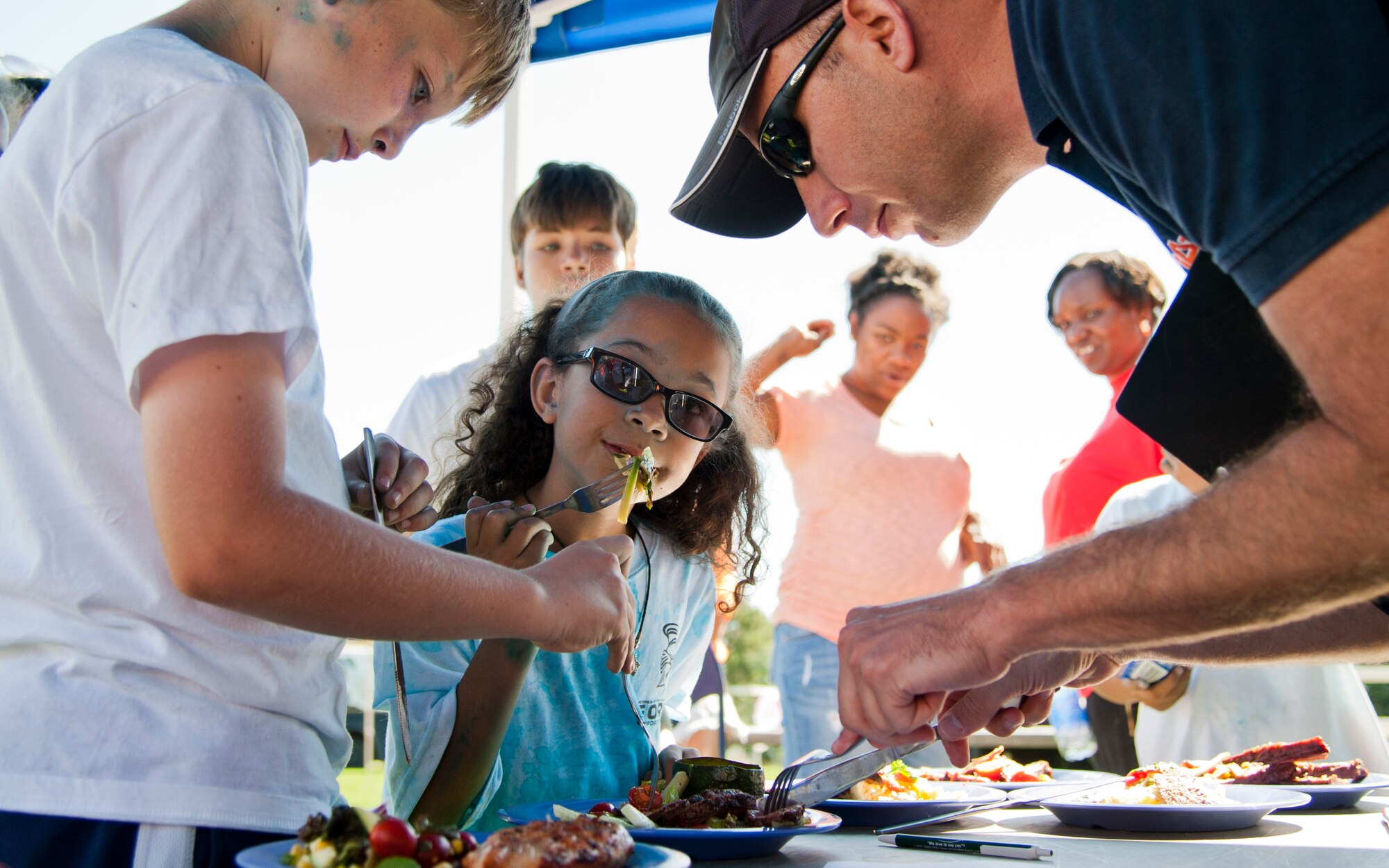 PETERSON AIR FORCE BASE, Colo. – Emmett McIlroy, Mariah Mobley, and E. Lindsey Buckalew taste test meals prepared by competitors in the healthy cooking challenge during Nickelodeon’s Worldwide Day of Play at Patriot Park, Sept. 26, 2015.  The annual event encouraged children to maintain active, healthy lifestyles through healthy snack choices, and outside activities including inflatable obstacle courses, a climbing wall, games and demonstrations from the Peterson Fire Station and Mobile Emergency Operations Center. (U.S. Air Force photo by Senior Airman Tiffany DeNault)