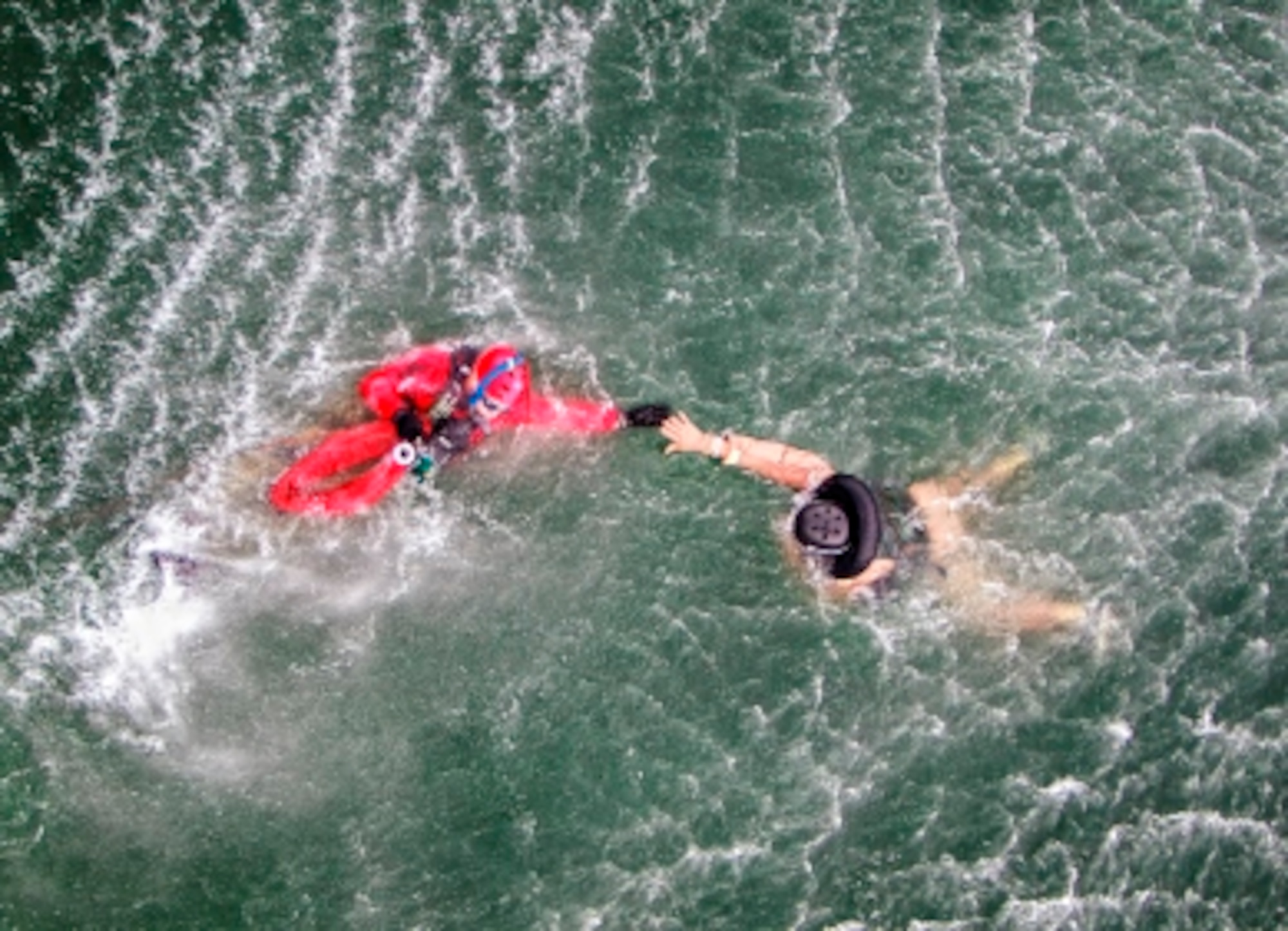 The PJs are hoisted down, they attach the pilot and lifted up while the helicopter is hovering over during water survival training in Key West, Fl., Sept. 14 - 18, 2015. (U.S. Air Force photo/Lt. Col. Jeremy Boyd)