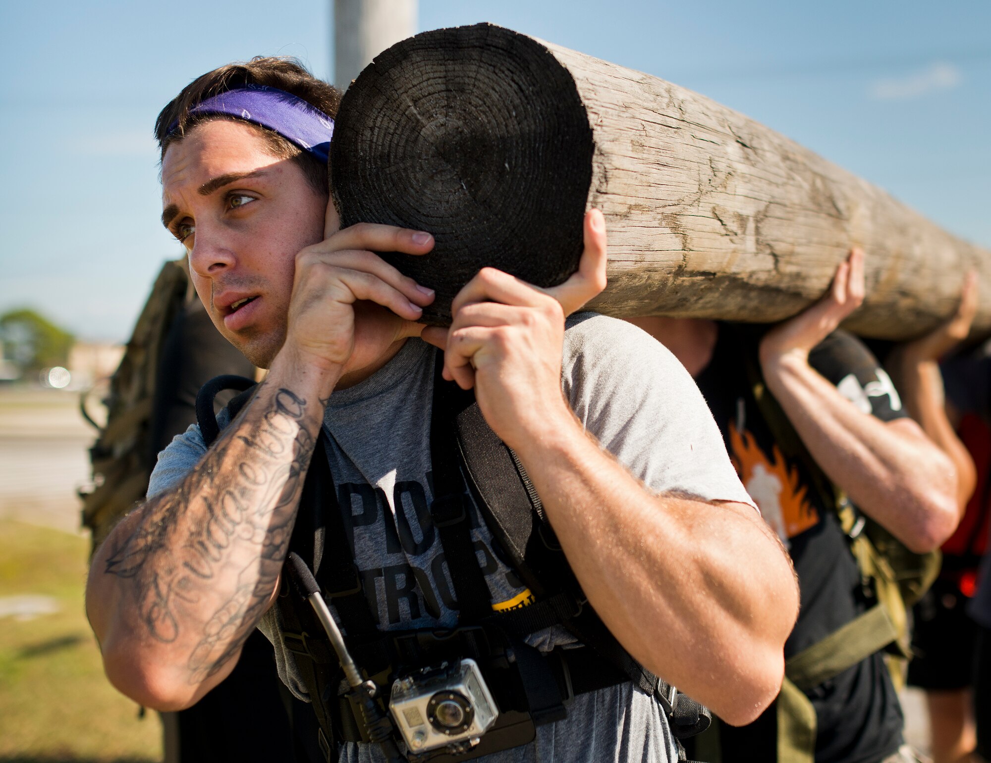 A participant guides the team carrying the largest wooden log during the GoRuck team building challenge Sept. 24 at Eglin Air Force Base, Fla.  More than 45 participants pushed themselves through the physical scenarios led by a Special Forces veteran, to earn the blue and black “GoRuck” patch.  (U.S. Air Force photo/Samuel King Jr.)