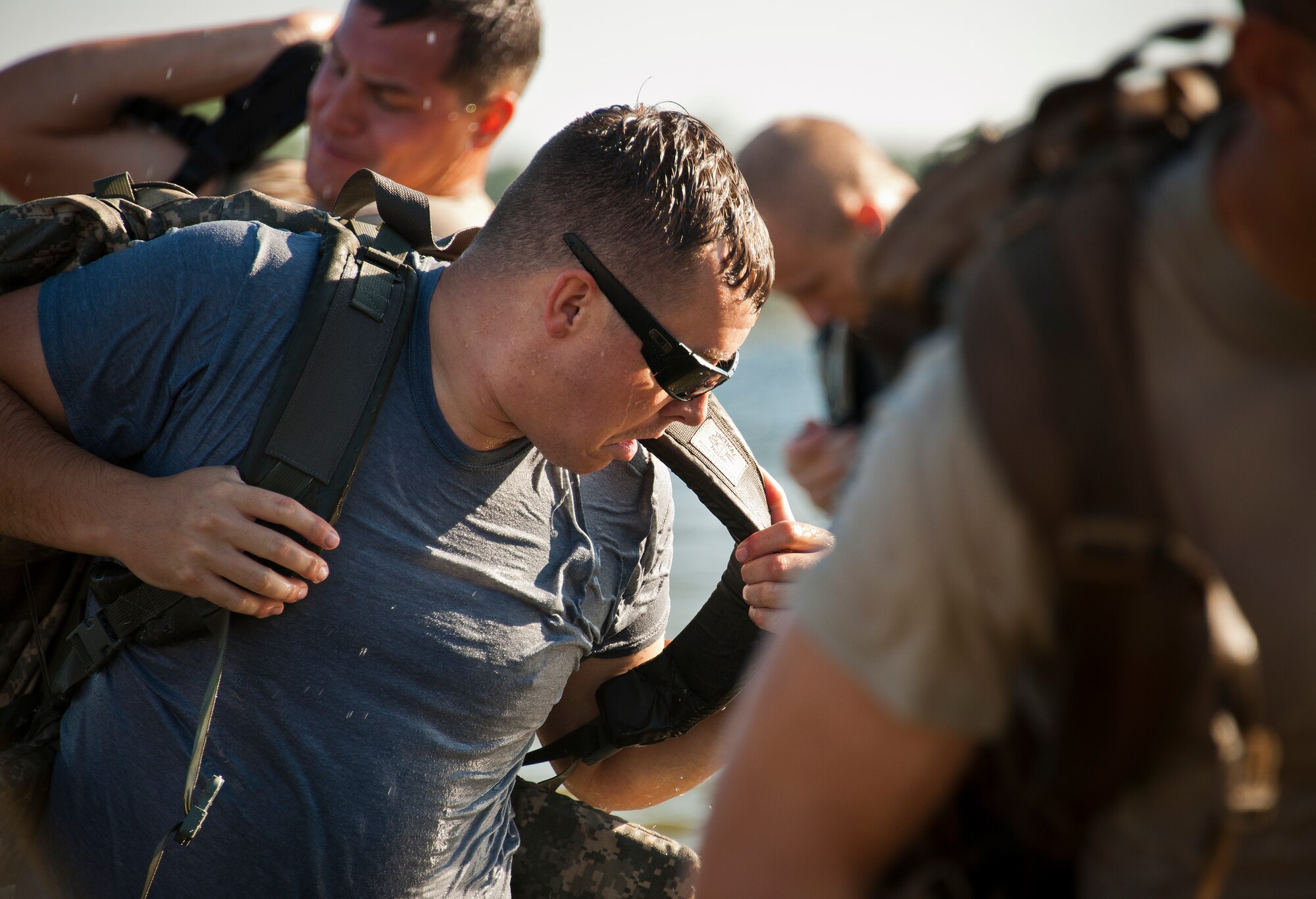 Airmen progress through the phases of putting on their rucksacks as they begin the GoRuck team building challenge Sept. 24 at Eglin Air Force Base, Fla.  More than 45 participants pushed themselves through the physical scenarios led by a Special Forces veteran, to earn the blue and black “GoRuck” patch.  (U.S. Air Force photo/Samuel King Jr.)