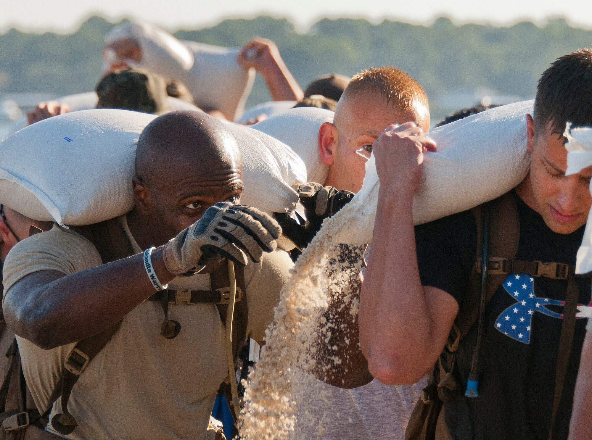 Staff Sgt. Willie Daniels, 366th Training Squadron Det. 3, reaches to help his buddy secure his sand bag as it falls open at the beginning of a march Sept. 24 during the GoRuck team building challenge at Eglin Air Force Base, Fla.  More than 45 participants pushed themselves through the physical scenarios led by a Special Forces veteran, to earn the blue and black “GoRuck” patch.  (U.S. Air Force photo/Samuel King Jr.)