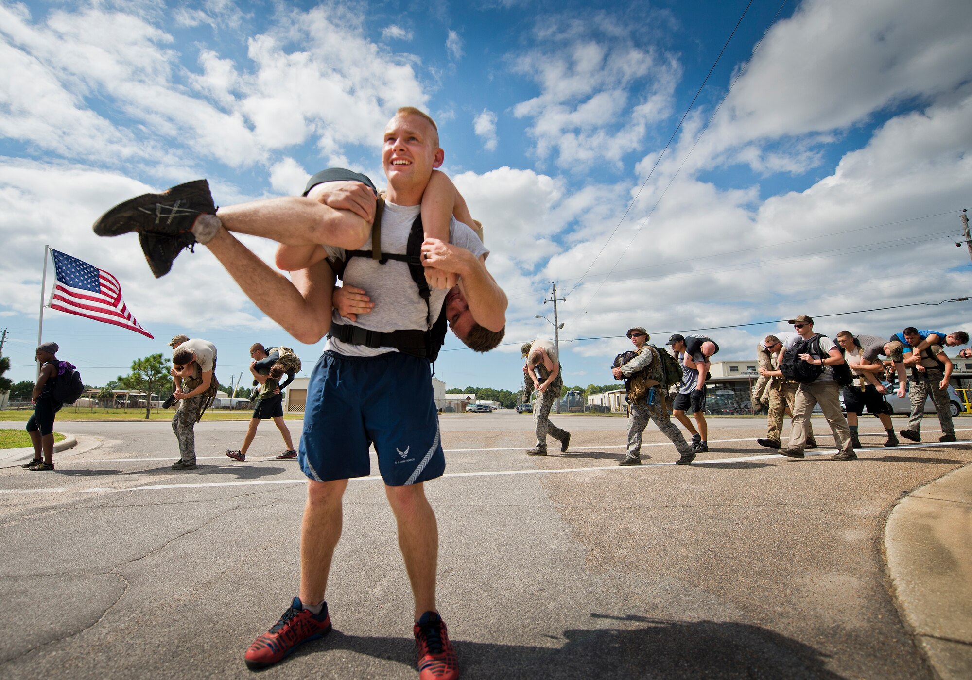 An Airman posts up as a road guard while carrying a simulated casualty on his back Sept. 24 at the GoRuck team building challenge at Eglin Air Force Base, Fla.  More than 45 participants pushed themselves through the physical scenarios led by a Special Forces veteran, to earn the blue and black “GoRuck” patch.  (U.S. Air Force photo/Samuel King Jr.)