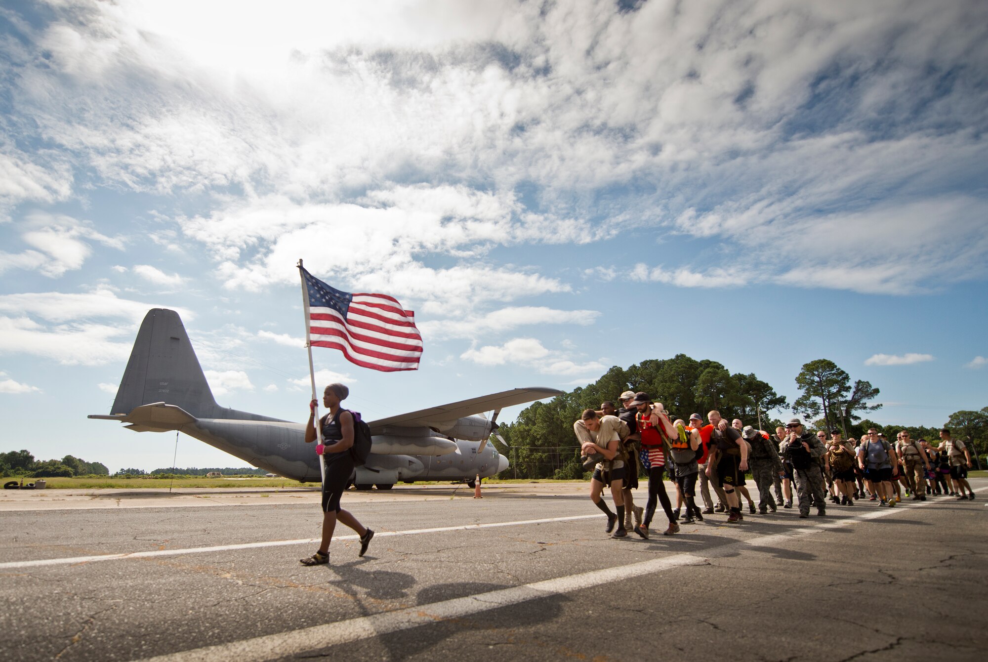 Participants march past the C-130 maintenance trainer carrying simulated wounded Sept. 24 at the GoRuck team building challenge at Eglin Air Force Base, Fla.  More than 45 participants pushed themselves through the physical scenarios led by a Special Forces veteran, to earn the blue and black “GoRuck” patch.  (U.S. Air Force photo/Samuel King Jr.)