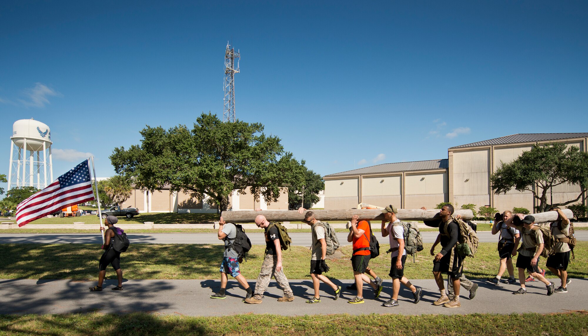 Participants continue their march carrying rucksacks and large wooden poles Sept. 24 at the GoRuck team building challenge at Eglin Air Force Base, Fla.  More than 45 participants pushed themselves through the physical scenarios led by a Special Forces veteran, to earn the blue and black “GoRuck” patch.  (U.S. Air Force photo/Samuel King Jr.)
