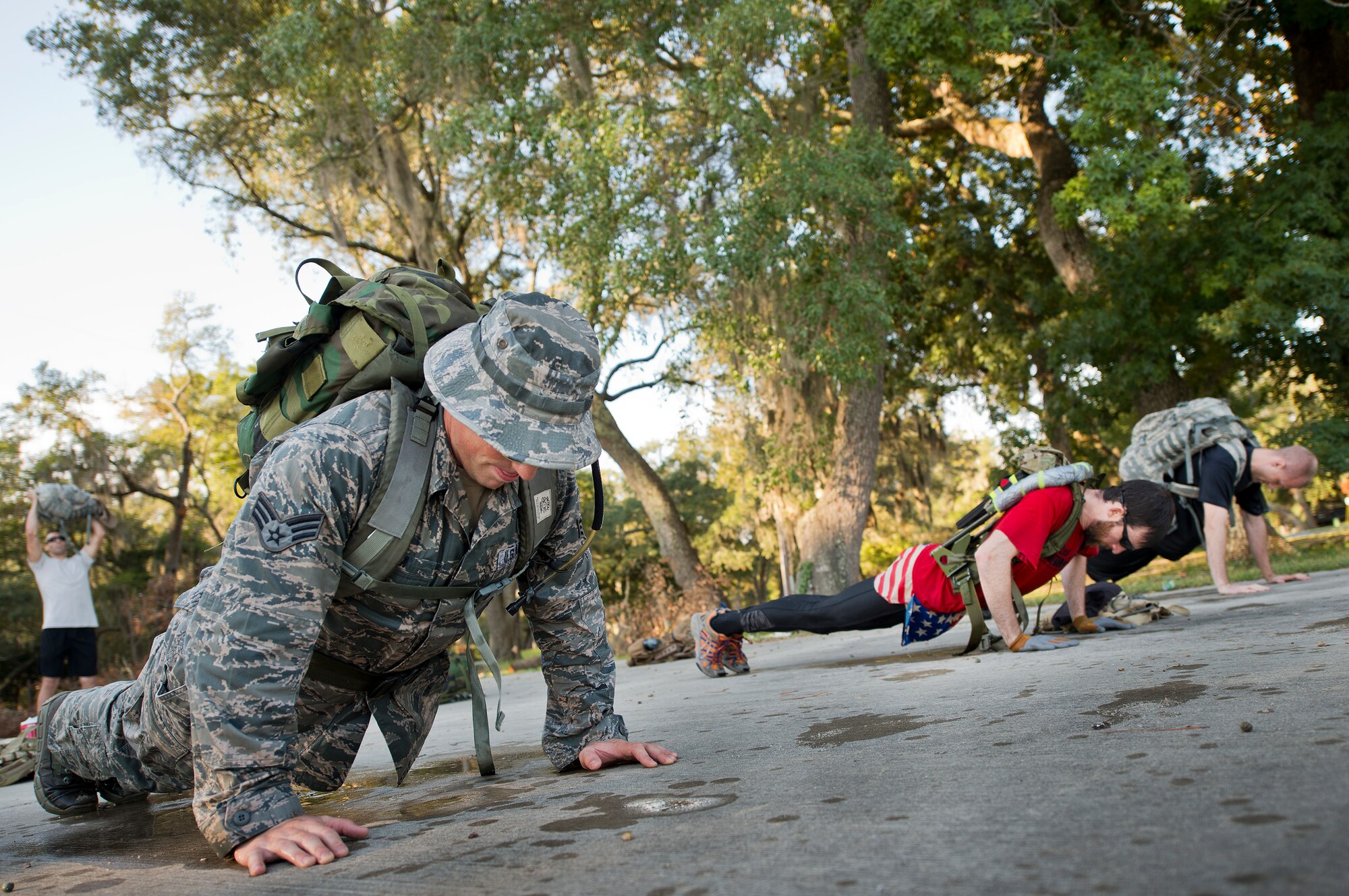 An Airman performs push-ups as part of the warm up exercises Sept. 24 during the GoRuck team building challenge at Eglin Air Force Base, Fla.  More than 45 participants pushed themselves through the physical scenarios led by a Special Forces veteran, to earn the blue and black “GoRuck” patch.  (U.S. Air Force photo/Samuel King Jr.)