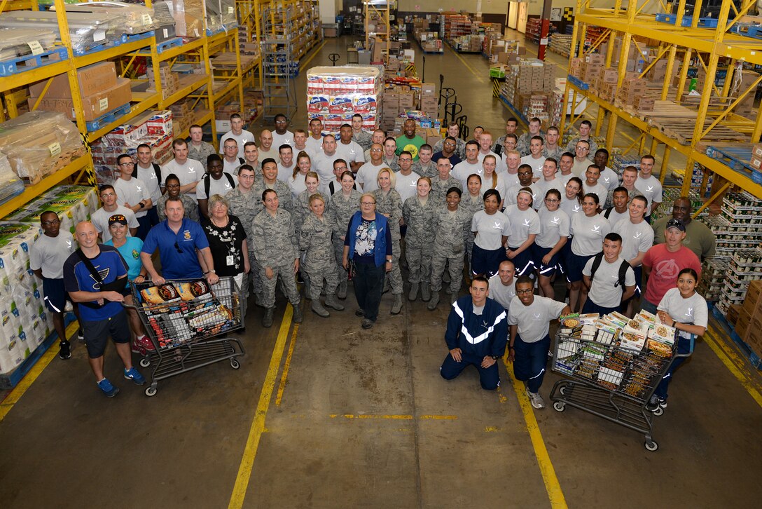 Airmen and civilians from Sheppard Air Force Base, Texas, take a group photo after restocking the commissary shelves with the rescued food from the night before, Sept. 27, 2015. These Airmen helped save nearly $200,000 worth of perishable items from the store shelves. United Grocers from the City of Wichita Falls also aided by loaning a 42-foot freezer truck to the base. (U.S. Air Force photo/Senior Airman Kyle Gese)