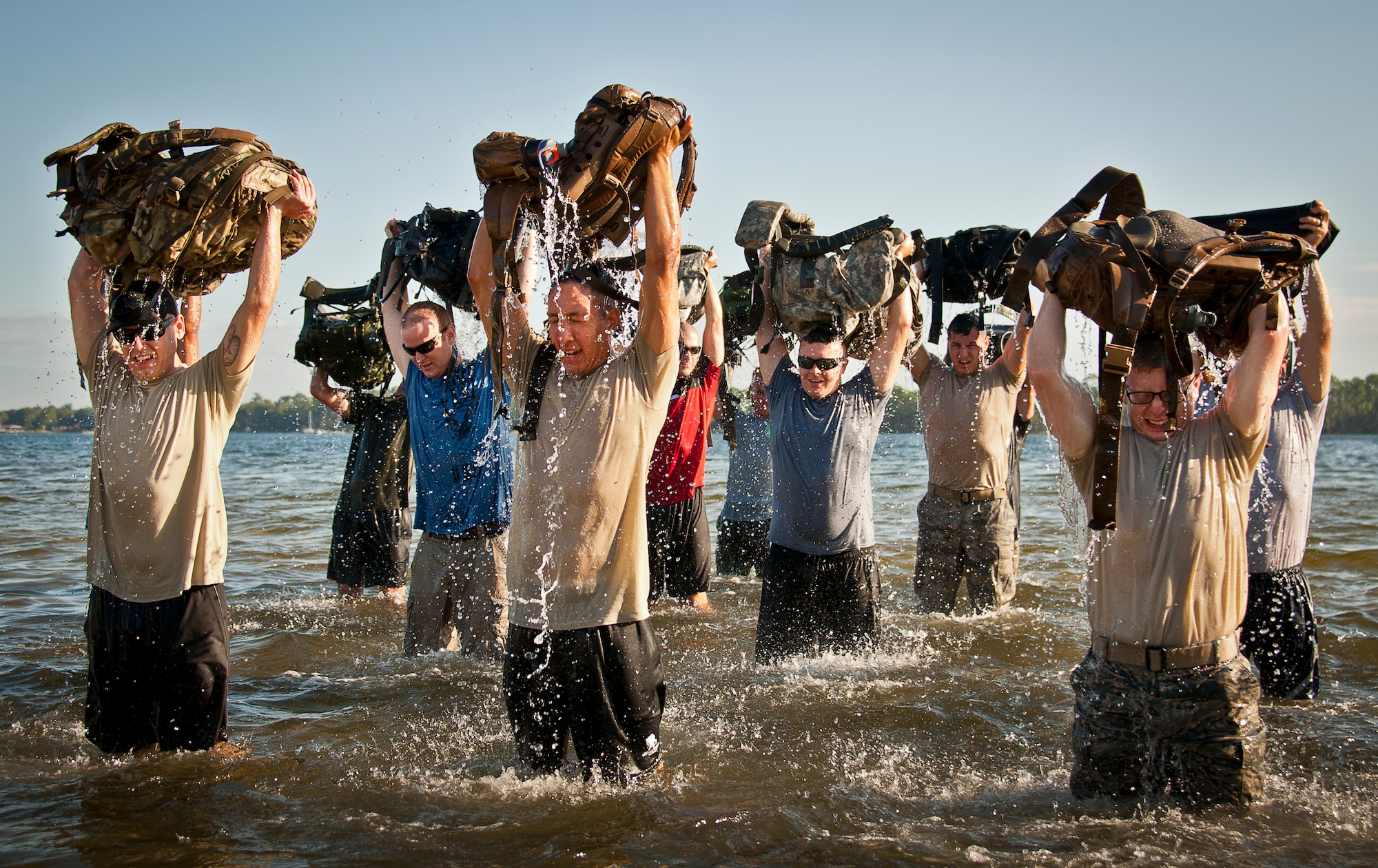 People lift their rucksacks above their head after dipping them in the water at Post’l Point Sept. 24 during the GoRuck team building challenge at Eglin Air Force Base, Fla.  More than 45 participants pushed themselves through the physical scenarios led by a Special Forces veteran, to earn the blue and black “GoRuck” patch.  (U.S. Air Force photo/Samuel King Jr.)