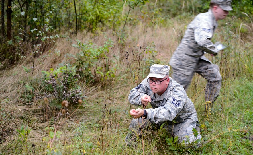 Tech. Sgt. Joshua Wisnewski, 7th Weather Squadron battlefield weather Airman, simulates conducting security as a fellow Airman crosses a street during a land navigation course Sept. 16, 2015, at Grafenwohr Training Area, Germany. Wisnewski and several other Airmen trained on basic Army and forecasting skills during the training exercise Cadre Focus. (U.S. Air Force photo/Staff Sgt. Armando A. Schwier-Morales)