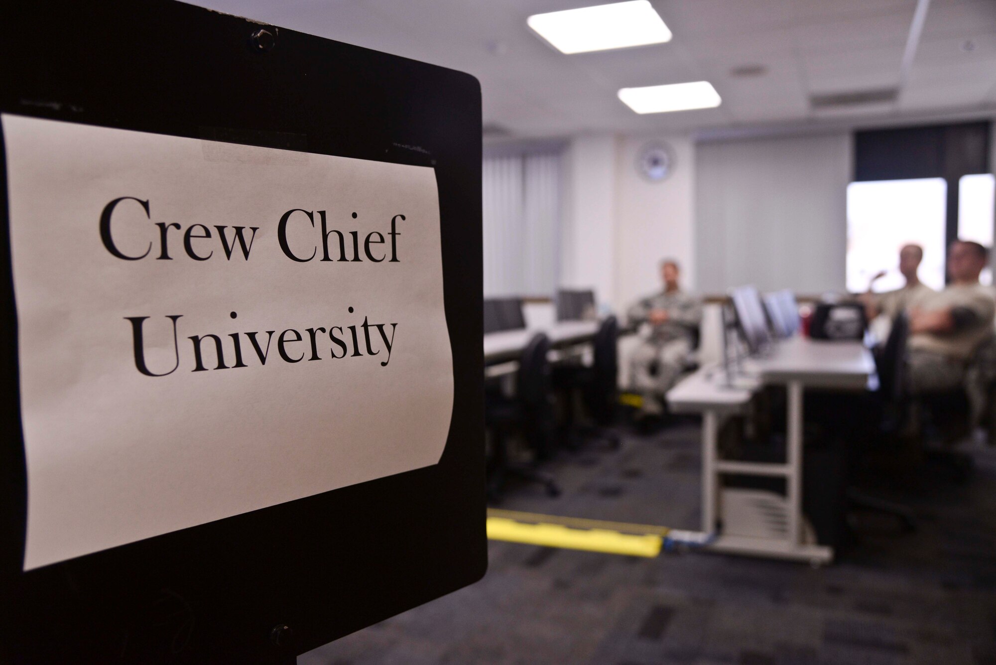 A sign is posted directing Airmen to the Crew Chief University course at MacDill Air Force Base, Fla., Sept. 28, 2015. The course has been developed to help aircraft maintainers better understand their mission, expand their knowledge, and improve their skills. (U.S. Air Force photo by Senior Airman Vernon L. Fowler Jr./Released)