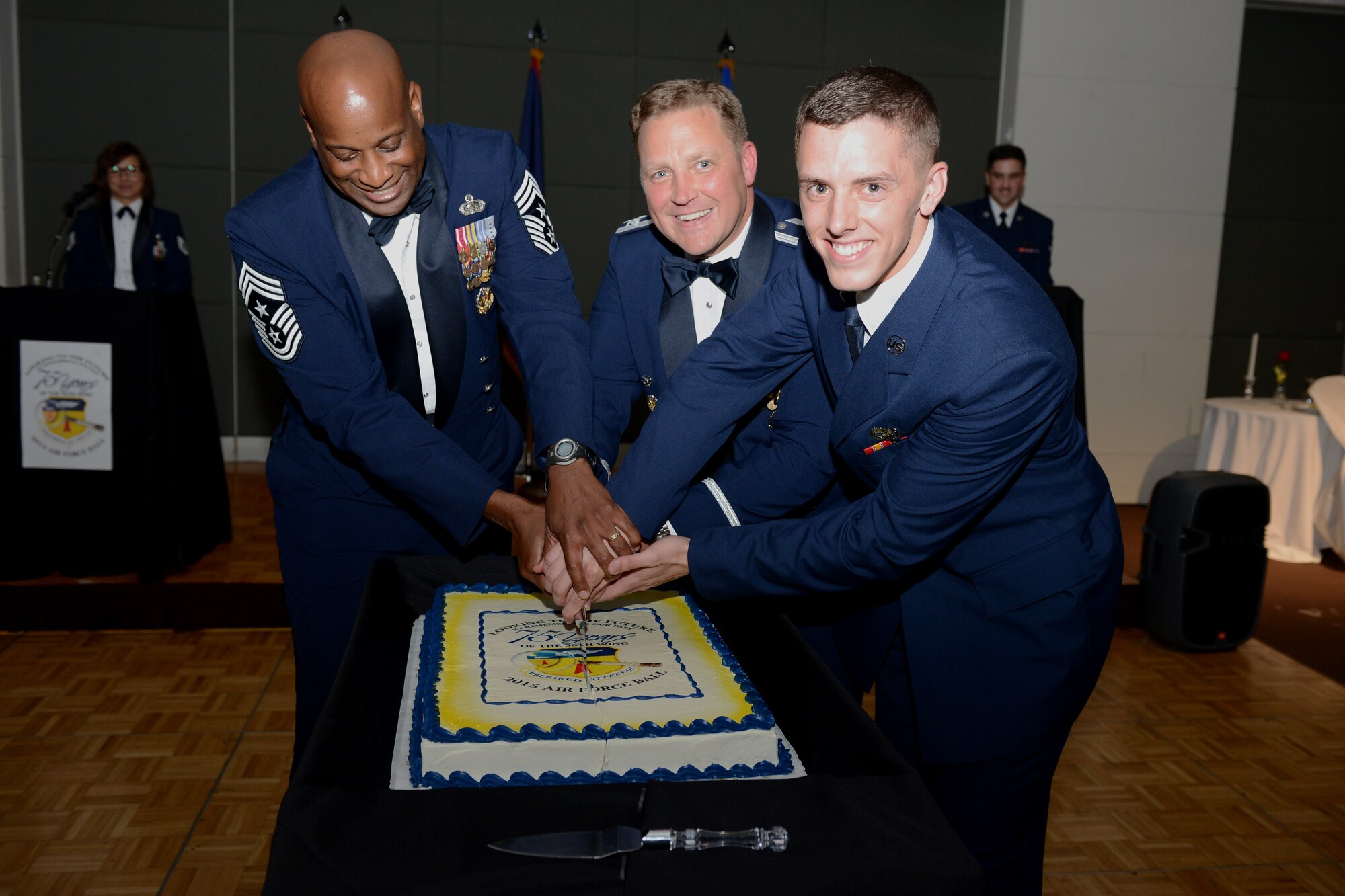 Chief Master Sgt. Michael McMillan, 36th Wing command chief, left, Col. Tyrell Chamberlain, 36th Wing vice commander, center, and Airman Derek Myers, 734th Air Mobility Squadron air transportation apprentice, cut the Air Force birthday cake at the 68th annual Air Force Ball Sept. 25, 2015, in Yona, Guam. It is tradition that the youngest and oldest Airmen, by time in service, cut the cake together during the ceremony. (U.S. Air Force photo by Airman 1st Class Arielle Vasquez/Released)