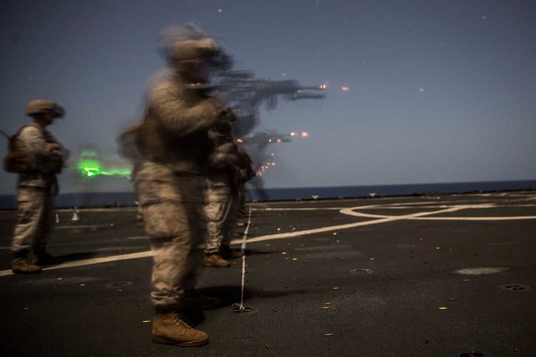 INDIAN OCEAN (Sept. 24, 2015) U.S. Marines with Kilo Company, Battalion Landing Team 3rd Battalion, 1st Marine Regiment, 15th Marine Expeditionary Unit, engage targets during a marksmanship qualification course aboard the dock landing ship USS Rushmore (LSD 47). The marksmanship course focused on sharpening basic marksmanship skills under the cover of darkness which prepares them for potential operations while deployed with the 15th MEU. The 15th MEU, embarked aboard the ships of the Essex Amphibious Ready Group, is deployed to maintain regional security in the U.S. 5th Fleet area of operations. (U.S. Marine Corps photo by Sgt. Emmanuel Ramos/Released)