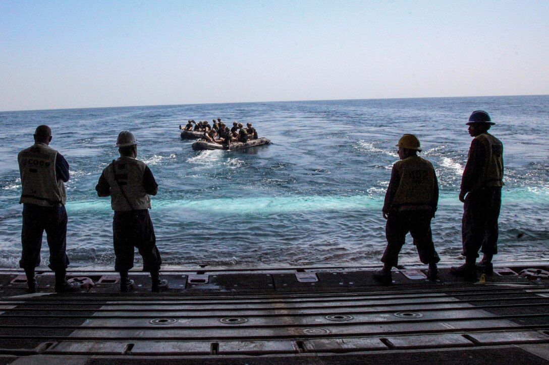 ARABIAN GULF (Sept. 26, 2015) U.S. Marines with the 15th Marine Expeditionary Unit’s Maritime Raid Force depart in combat rubber raiding craft from the well deck of the amphibious assault ship USS Essex (LHD 2).  The MRF tested the engines of their CRRC’s in order to maintain combat readiness. The 15th MEU, embarked aboard the ships of the Essex Amphibious Ready Group, is deployed to maintain regional security in the U.S. 5th Fleet area of operations. (U.S. Marine Corps photo by Cpl. Elize McKelvey/Released)