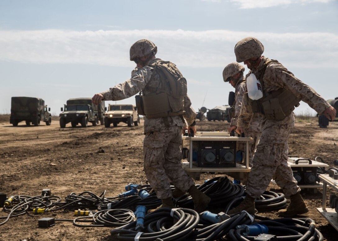 Marines with Company B, 9th Communication Battalion, I Marine Headquarters Group, carry a power source during a communications exercise aboard Marine Corps Base Camp Pendleton, Calif., Sept. 22, 2015. During the COMMEX, the Marines received training through hands-on application in establishing clear radio communications which are essential to the command element on the battlefield. (USMC photo by Pfc. Devan Gowans)
