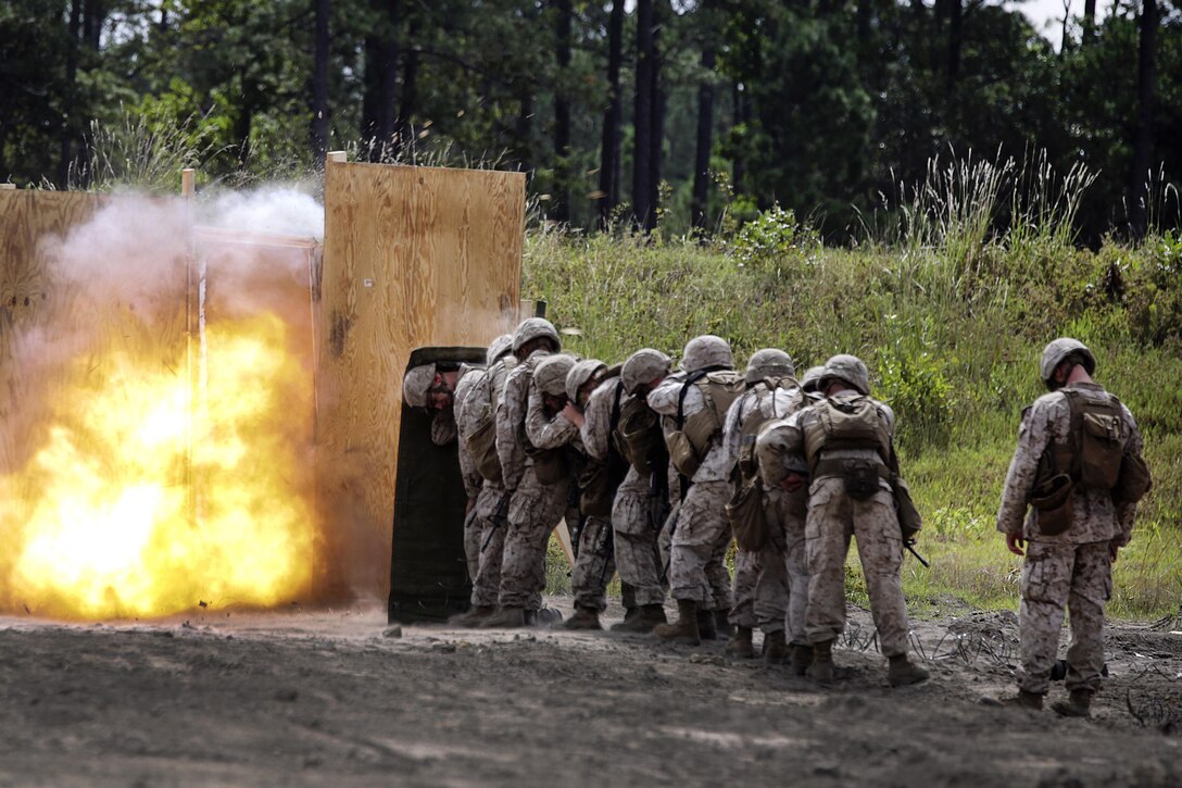 Marines take cover behind a shielding blanket as a charge detonates during a demolitions exercise on Camp Lejeune, N.C., Sept. 22, 2015. U.S. Marine Corps photo by Cpl. Alexander Mitchell